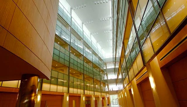 This image of the atrium shows several stories divided by large, glass-panel banisters.